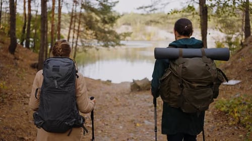 Couple Hiking with Backpacks Through Autumn Forest