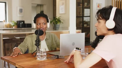 Divers co-animateurs parlant dans un micro et écoutant avec un casque pendant l'enregistrement en studio