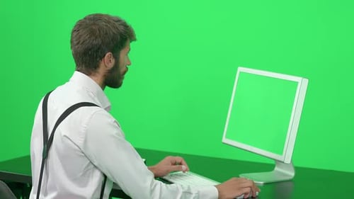 Focused Software Developer Working on a PC While Sitting at a Desk Green Background Chroma Key