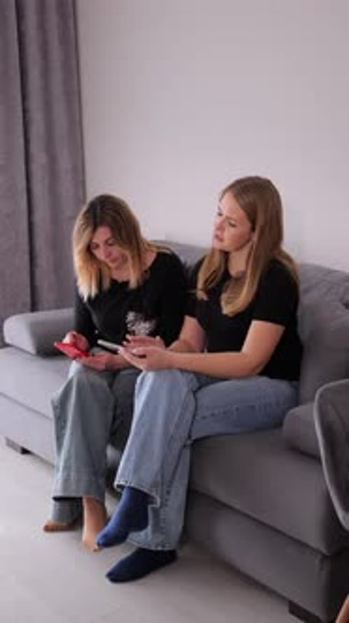 Two Friends Sharing Digital Tablet on Couch