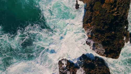 Rough ocean waves crashing on volcanic cliffs in slow motion breathtaking coastal view