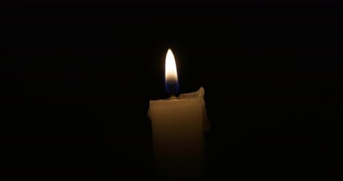 Die Kerze brennt mit einer weichen gelben Flamme
