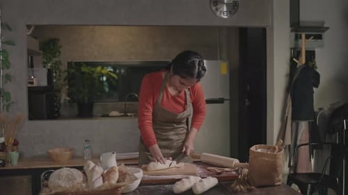 Woman Slicing Bread in Kitchen