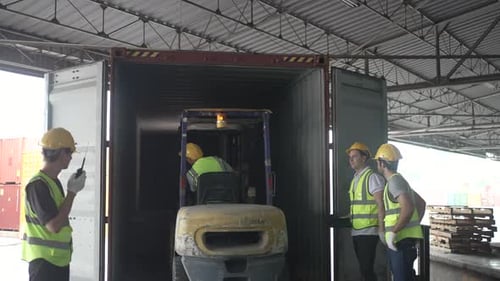 Blue collar workers are working at warehouse.