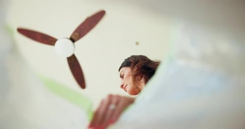Woman Pours Liquid into Bag from Low Angle
