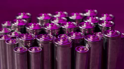 Group of New Batteries Standing Against Purple Background