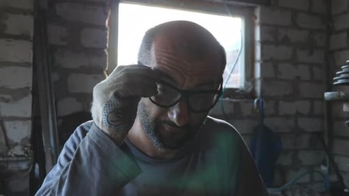 Professioneller Mechaniker setzt Schutzbrillen auf, um in der Werkstatt zur Arbeit zu kommen