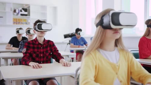 Teenagers using VR headsets in a classroom setting