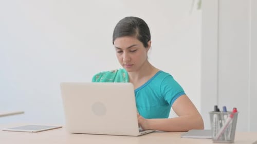 Woman Typing on Laptop Computer at Office Desk