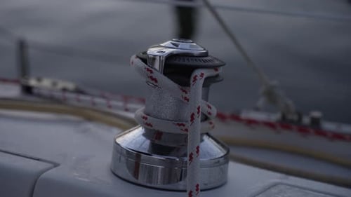 This stock video footage features a close-up detail shot of a winch on a sailboat.