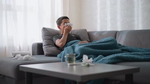Teen Boy With Cold Lying on Couch