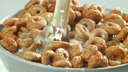 Close Up of Milk Pouring Onto Ring Cereal