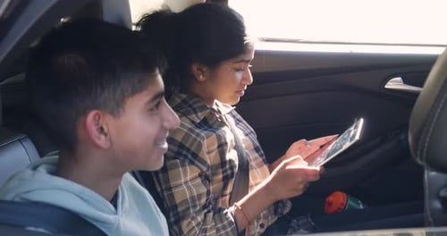 Teens Riding in Car Looking at Tablet Device
