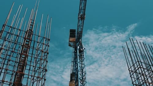 Grúa torre entre jaulas de refuerzo en el sitio de construcción