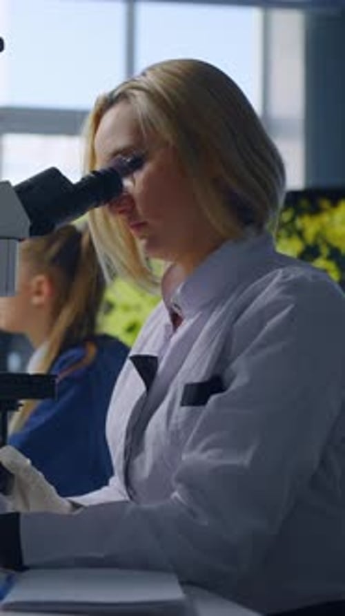 Female Scientist Using Microscope in Lab