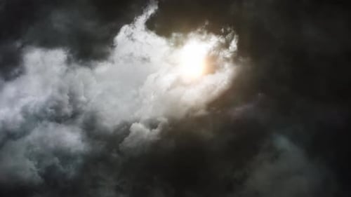 thick dark clouds moving in the sky with sunlight behind them