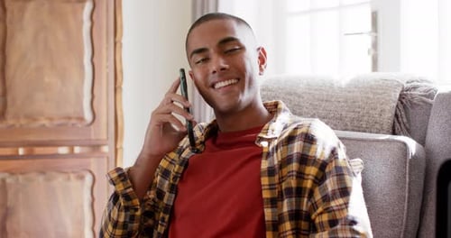 Smiling Young Adult Chatting on Phone Indoors