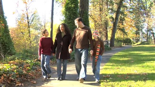 Happy family enjoying an autumn walk together in the park with smiling faces
