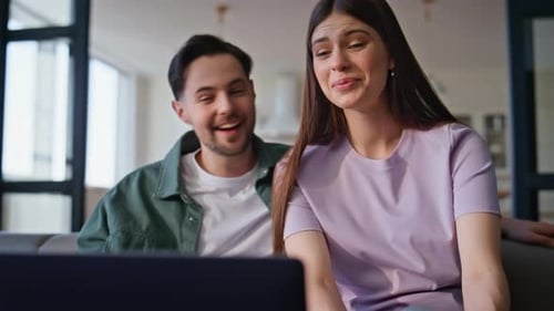 Smiling Young Couple Video Chatting on Laptop