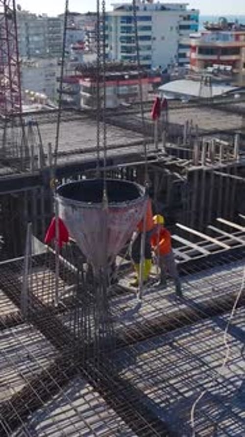 Vertical Video of a Construction Site Captured From Above Showing Workers Preparing Concrete for a