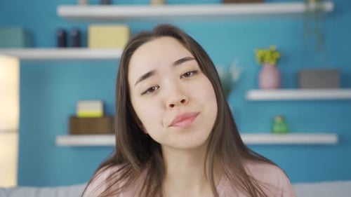 Close-up portrait of young Asian woman feeling tired and exhausted at home.