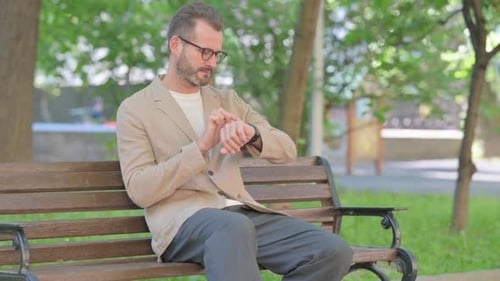 Stylish Man Checking Watch on Park Bench