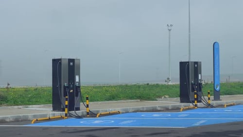 Two DC EV chargers against a background of open space in a rural area