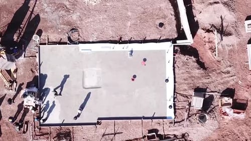 Zumbido desciende a la estructura de un edificio de cemento en un sótano en Europa central con trabajadores siendo producidos