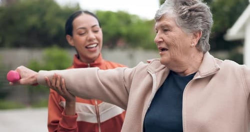 Senior Woman Exercising with Young Adult Instructor