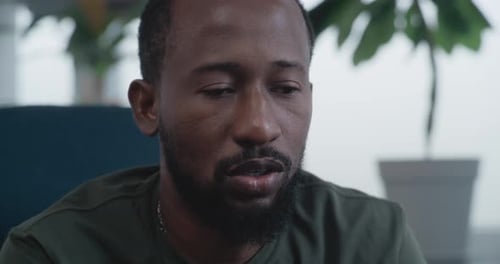 Close Up of African American Military Man with PTSD Sharing Traumatic Experience on Therapy Session