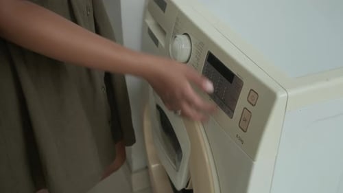 Woman Closes and Sets Washing Machine Close Up