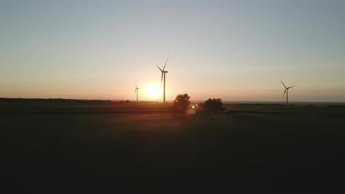 Drone Aerial Wide View of a Wind Park with Wind Turbines Standing in a Wheat Field and Farm at