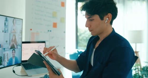 Young freelance Asia male use laptop talk to colleague plan in video call meeting on desk.