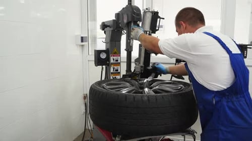 Auto Tech Swaps Seasonal Tires Using Modern Machine in Shop Vehicle Maintenance with Tire Changer