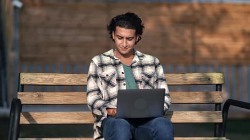 Spanish Modern Guy Freelancer Programmer Business Developer Working Laptop at City Park Bench