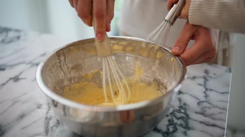 Baby girl hands mixing dough helping mom bake pastry at home kitchen indoors