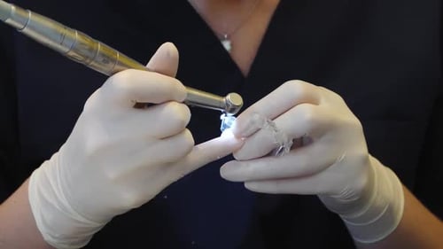 dental professional using a drill to adjust Invisalign aligners