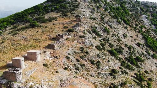 Drone volant à basse altitude au-dessus des pentes abruptes, arides et irrégulières d'une immense montagne. Journée ensoleillée.