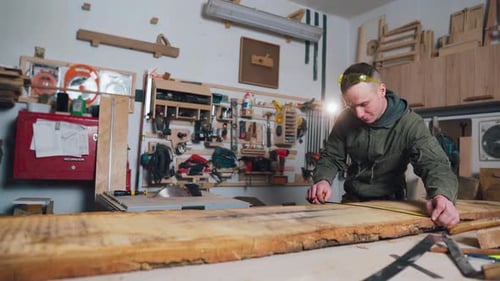 Carpenter Measuring Wood Plank in Workshop