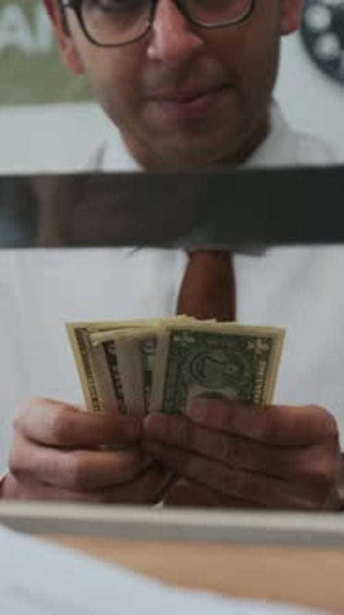 Cajero de un banco indio cuenta una pila de dinero en efectivo