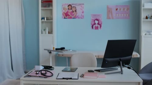 Doctors Office with Computer on Table and Posters on Wall in Background