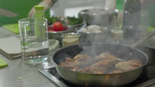 Fry pieces of meat in a frying pan. Frying chicken hot oil in frying pan, close-up.