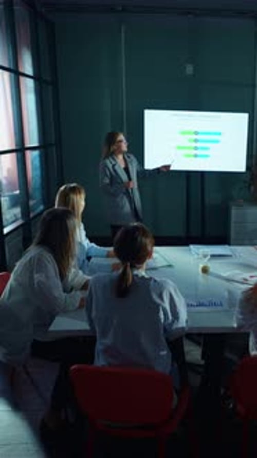 Female Scientist Presenting Research Data on Digital Screen to Laboratory Team During Analytical