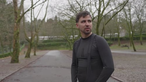 Man adjusting fitness strap on empty park road