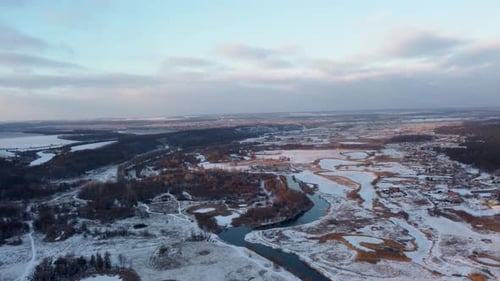 Winter aerial sunset view on snowy river valley