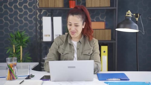 Young Adult Woman Working Happily At Her Desk