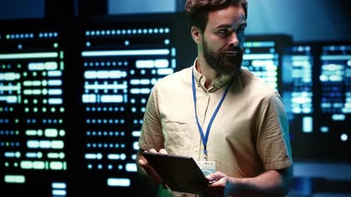 Bearded IT Specialist Using Tablet in a High Tech Server Room