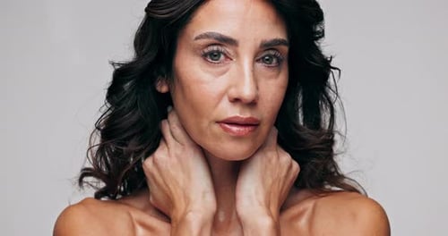 Beauty, face and serious mature woman in studio isolated on white background for dermatology