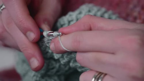 Female Hands Knitting With Crochet Hook And Yarn - close up
