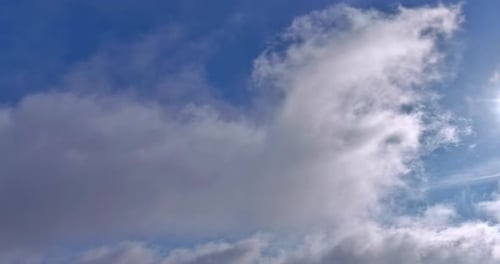 Dramatic Clouds Drifting Across Sunny Blue Sky